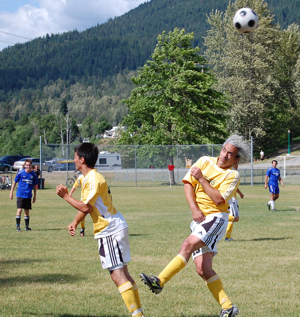 Louie Fuscaldo (center, right) grimaces as heads the ball during the Revelstoke Football Club’s final match against the Williams Lake Lightning last Sunday. And, no, he’s not kicking his son, Landon (center, left). David F. Rooney photo
