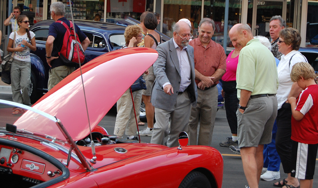James Baring, Lord Revelstoke, must know something about vintage MGs as he points out to Mayor David Raven and Alan Chell of the Homecoming Committee some of the features beneath the hood of this red model on display at the 2009 Homecoming Vintage Auto Show-N-Shine on Mackenzie Avenue on Friday. David F. Rooney photo