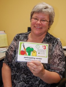 Patti Larson poses with one of the coupons being offered to eligible families in the BC Farmers’ Markets’ Nutrition and Coupon Project. David F. Rooney photo