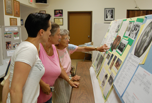 Karry Dinsdale of Cranbrook (left), her sister Barb Abel of Kelowna and their mother Ellen Fuoco of Revelstoke examne the family history on display at the Community Foundation's Family Tree display at the Fire Hall on Sunday. Hundreds of past and present residents visited the display. David F. Rooney photo