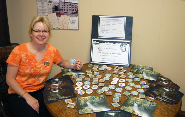 The Revelstoke Museum's Marilee Planden poses with the small display set up to raise money to purchase a headstone in the memory of 12 Mile ferryman Edward Mulvehill who was buried without a tombstone even though several local landmarks were named after him early in the last century. David F. Rooney photo