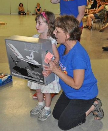 Assistant Librarian Zoe Knuff shows young Ava Keerak the prize she won in this year's Summer Reading Club. Photo courtesy of Revelstoke Public Library