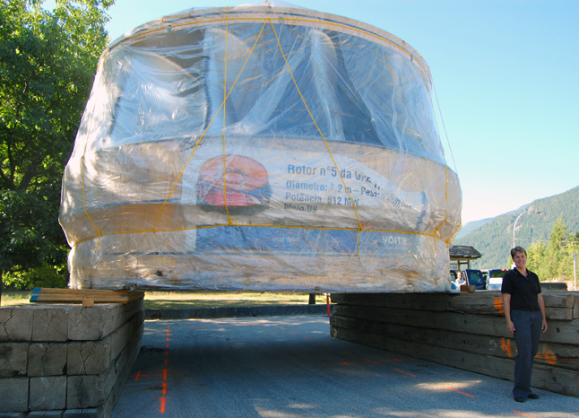 BC Hydro spokeswoman Jennifer Walker-Larsen poses beside the mammoth stainless steel turbine that is awaiting the arrival of a special transport truck at Shelter Bay. Transported by ship to Washington state and then by truck and barge up the Columbia River to the local ferry landing, it is to taken to the Revelstoke Dam's Unit 5 project this weekend. David F. Rooney photo 