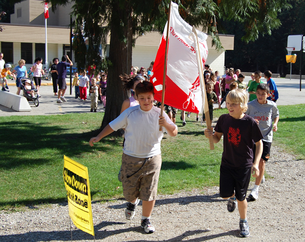 Waving the Tderry Fox banner, kids at Arrow Heights Elementary School stream out of the school yard for AHE's annual Terry Fox Run last Friday. David F. Rooney photo