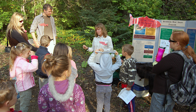 Bear Aware Coordinator Penny Page Brittin (center) talks with children at the Kokanee Fshg Festival about the relationship between bears and red fish. David F. Rooney photo