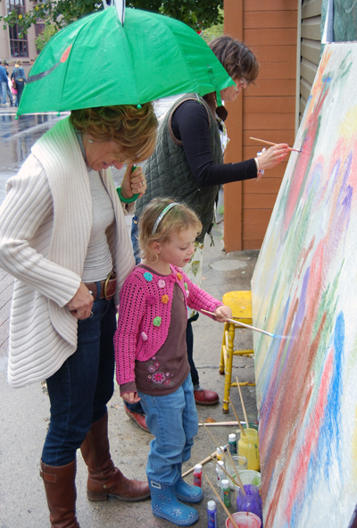 Sally Carmichael's daughter, Holly, exhibited her artistic streak by helping paint the community mural in front of Castle Joe Books. David F. Rooney photo