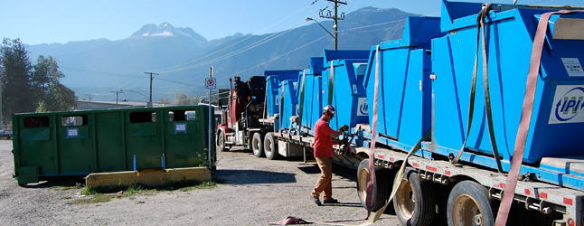 A trucker tightens the straps securing the old blue bins he was carting away from the CSRD's recycling area on Vernon late Thursday morning. The bins have been replaced by a new co-mingled green bin. David F. Rooney photo