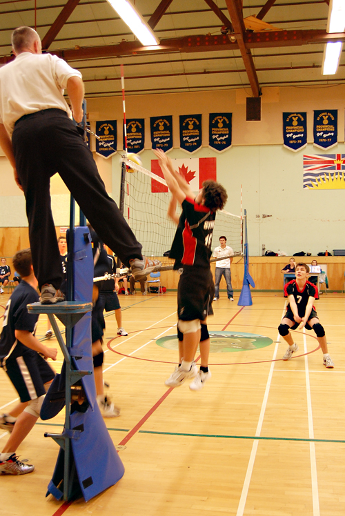 Jake Wallach leaps (center) to block the ball as Devin Camara (right) is in position to hit it if it is returned by the Oakanagn Mission team. David F. Rooney photo