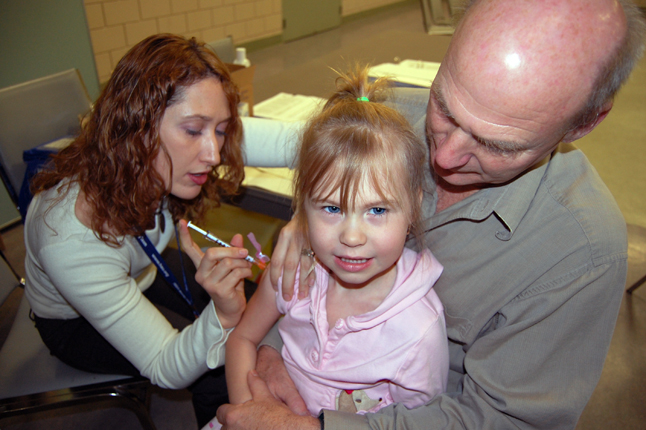 Secure in the arms of her grandfather, Alan Chell, young Lauryn Kline received an H1N1 flu shot from Kelsey Croxall this morning. David F. Rooney photo