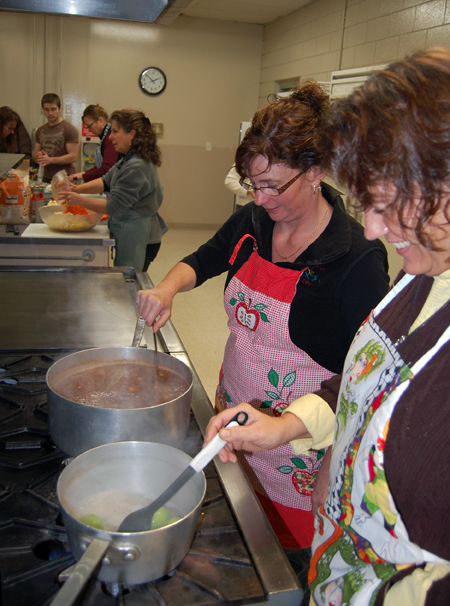 Tammy Kermack tends a pot of tortilla soup while Elena Bishop stands watch over cooking tomatillos. David F. Rooney photo