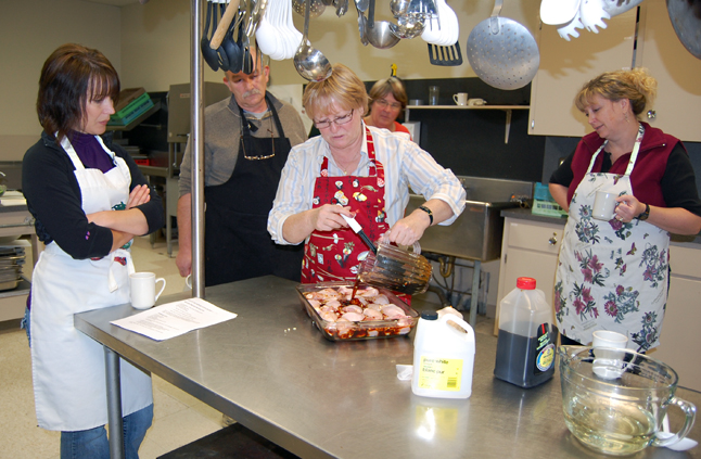 As students look on, Instructor Ginger Shoji pours her special teriyaki sauce over a pan full of chicken. David F. Rooney photo