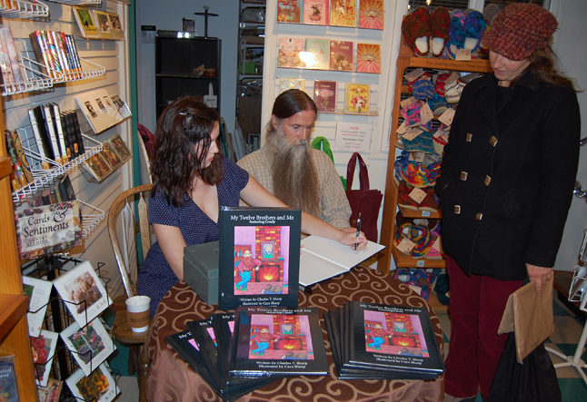 Cara Sharp (left) signs a copy of My Twelve Brothers and Me for Jacki James (right) as her father, Chick, waits for the pen. Chick wrote the book, which is the first in a series of 13 books recounting tales he used to tell Cara and her siblings when they were young. While Chick handled the writing, Cara provided the gay and delightful illustrations. You can find the Sharps' children's book at Grizzly Books and online at www.mytwelvebrothersandme.com. David F. Rooney photo 
