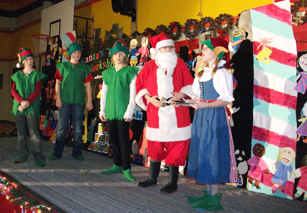 Santa and his accountant crunch the numbers determining how they will meet the demands of Christmas.  Santa agrees to become a participant in the Game Show School Kids are Smarter to meet this year's balance sheet.  L-R: Elfs: Myah Kramer, Joel Holdner, Kyler Lenzi, Santa: Kayla Fenwick, Accountant: Erin Behncke. Photo courtesy of Todd Hicks