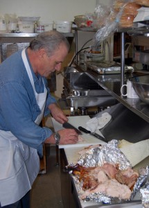 Volunteer Stanley Darland slices up turkey in the kitchen at the Frontier Family Restaurant. He;s just one of the many people who volunteer their time to help make the Community Christmas Dinner a special event for people who are alone and, perhaps, lonely for fellowship on Christmas Day. David F. Rooney photo