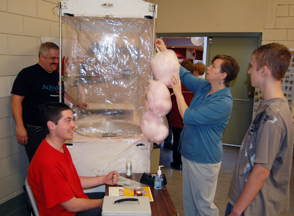 Mcpl. Dustin Andrew (center, left in red) and Cpl. Tyler Coley (right) had a sweet job fronting for the cotton candy being whipped up by Rocky Mountain Rangers Capt. Kelly Rienks and hung out for display by Suzanne Tippe. David F. Rooney photo