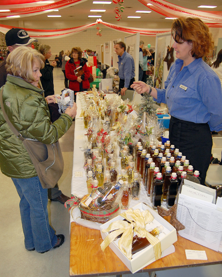 Elvira Brunner (right) of Crescendo tells a potential customer about the superior quality and variety of the oils and spices she and her partner Daniel Weber (center, right background) have on offer. David F. Rooney photo