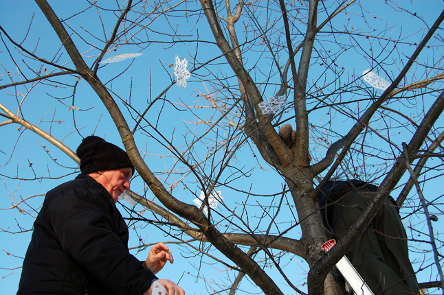 Holloway and Battersby hang the snowflakes. David F. Rooney photo