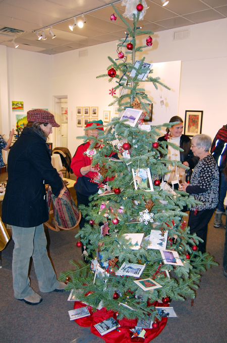 Jackie James (left) contemplates a purchase from the Christms Gift Tree at the Revelstoke Visual Arts Centre's Affordable Art Fair on Friday evening. Local artists have produced affordably priced paintings, sculptures, cards, photographs and other sensory delights to fit any pocketbook. The Fair runs until Dec. 20 and the gallery will be open every day until then from 1 pm until 5 pm. David F. Rooney photo