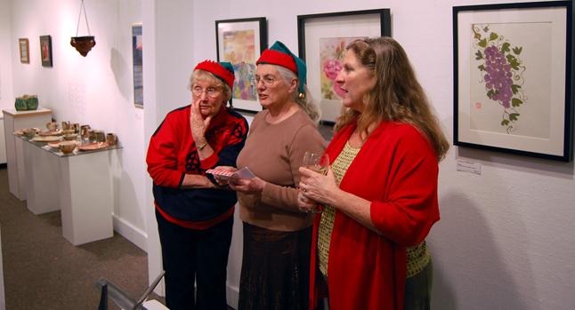 Pat Anderson (left) whispers to fellow artist Sandra Flood as Carol Palladino looks on at the Affordable Art Fair. Not only did Anderson and Flood have paintings and ceramics on offer, their festive head gear singles them out as official exibitors at the show. As for Palladino, she was no doubt shopping for the perfect gift for someone. David F. Rooney photo