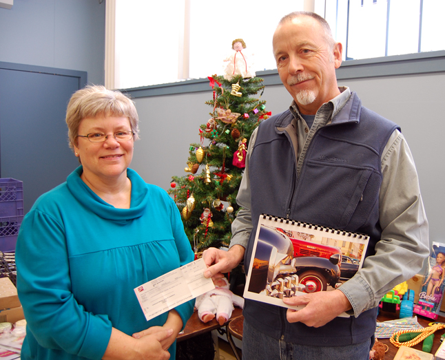 Brent Lea (right) hands Community Connections Food Bank Coordinator Patti Larson a cheque for $4,265 he personally raised by conceiving, designing and printing a calendar featuring local vintage automobiles. Lea sold the calendars through local businesses and by hitting every conceivable public event for the last several months. Every dime from the calendar sales went to the Food Bank. His extremely generous donation of time, effort and money deeply moved Larson. "This was something he didn't have to do," she said after the presentation. "He just wanted to make a difference and he chose the Food Bank. I simply don't have the words to express my appreciation for this." David F. Rooney photo