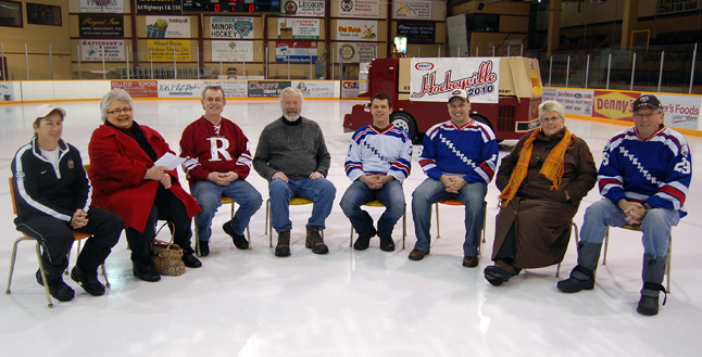 David Rooney (center), publisher of The Revelstoke Current and host of the RCTV program In Conversation, poses with members of the Revelstoke Hockeyville Committee moments before interviewing them on center ice at the Forum about the city's bid to become Hockeyville 2010. From left to right are: Nel Lord, Catherine Bell, Dennis Berarducci, Eric Scarcella, Committee Chairman Gary McLaughlin, Brenda Diebert and Garth Elrick. The Committee hopes for a major show of support for the bid this Friday, when the Grizzlies meet the Chase Chiefs. The game will be a kind of Revelstoke Hockeyville special with draws for a hand-made quilt by Suzie Cameron and a valuable set of hockey cards. people will also be able to submit their own stories about the Forum and thereby have a chance of winning the two nights accommodation in Vancouver and the two tickets to the March 18 Canucks game against the San Jose Sharks. For more information, including submission guidelines, please go to www.revelstokehockeyville.com. Photo courtesy of Shawn Fillipchuk
