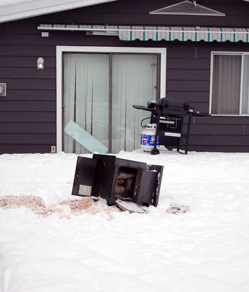 A pellet stove lies in the snow in front of the residence where fire fighters dragged it after a residential fire in the 1900 Block of Laforme Boulevard Thursday evening. David F. Rooney photo