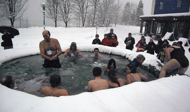 Gord Robinson stands in the water, bracing himself before immersing his body in the icy waters of the Polar Plunge Pool. The two men in back, Tony Rota (wearing the hat) and Lucas Schneble won the Longest Male Plungers category. They withstood the bine-chilling temperatures for more than 21 minutes. David F. Rooney photo