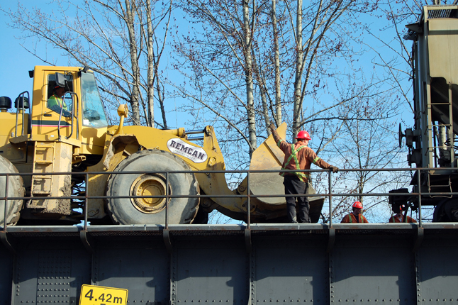 A worker guides the wheel loader in close so he can lift back onto the rails. David F. Rooney photo