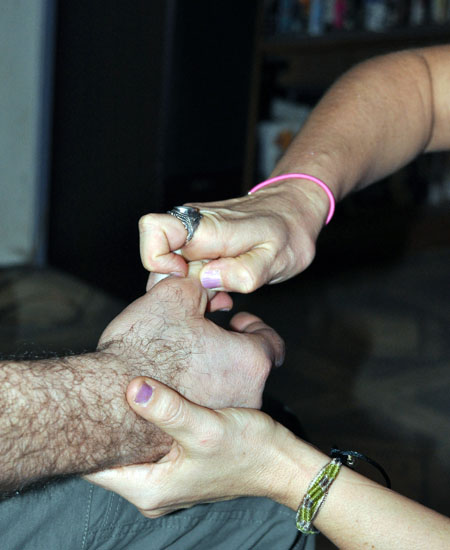 Barbara's fingers apply pressure to a specific point on Geordie's right hand. David F. Rooney photo