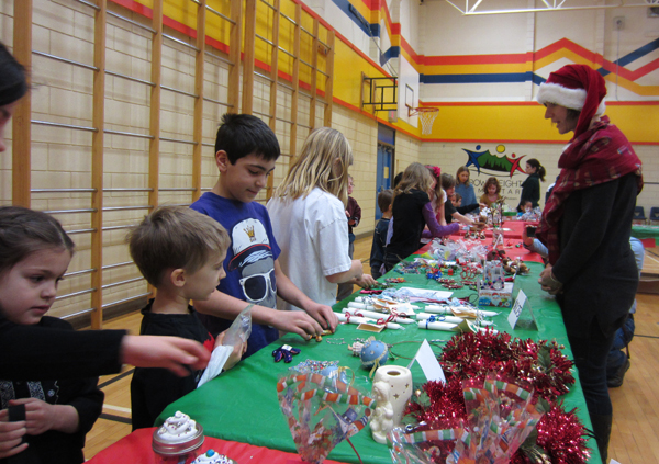  Suri Stewardson, Myles Mitchell and Landon Camara check out craft items in the gym at the AHE Craft Fair on December 14.  The Fair gives students an opportunity to do all their Christmas shopping for their friends and families.  Thank you to our amazing PAC! Photo and caption by Julian Corbett 