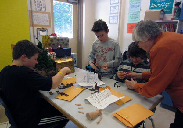 Mrs. Allsopp shows Conner Templeton, Caine McCabe, and Brandon Lavers how to sew.  The Christmas mice are a class project in Mrs. Gadbois’ class atArrow Heights Elementary School.  Mrs. Allsopp is Mrs. Gadbois’ mom.  She comes every year and volunteers her time to help students with their Christmas art projects.   Photo and caption by Julian Corbett 