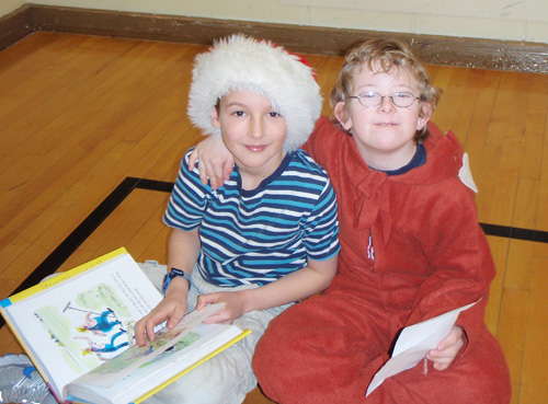 Austin Des Mazes and Daniel O’Hagan are reading Curious George on Literacy Day in the AHE gym. Julian Corbett photo and caption