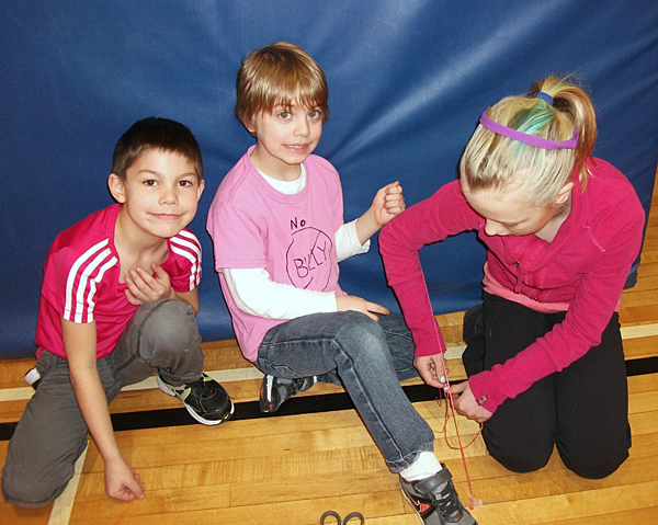 Kurtis Kinoshita, Ryder Litke, and Alexis Larsen make friendship bracelets in the gym at Arrow Heights Elementary School on February 27 for an Anti-Bullying Day Buddy Activity. Photo by Student Photographer Julian Corbett