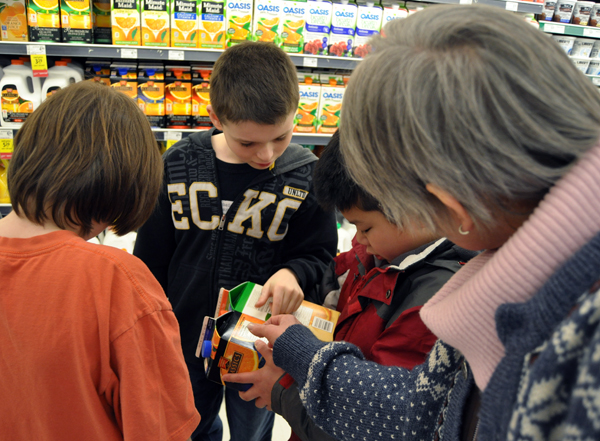 Kaeson Newsome (in orange shirt), Tyson Sessa, and Victor Wu discuss the merits of different brands of orange juice with teacher Sue Leach. David F. Rooney photo