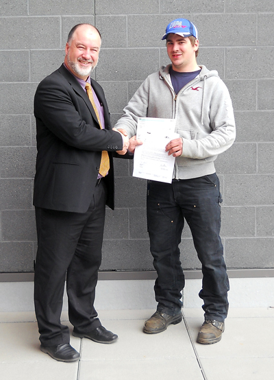 RSS Principal Greg Kenyon (left) presents a $1,000 Secondary School Apprenticeship Scholarship to Josh Zahacywho will use it to assist to further his career as an Apprentice Automotive Technician with Grizzly Auto. Josh started his apprenticeship while attending RSS.  Secondary School Apprenticeships offer students the opportunity to register as an apprentice and receive 16 credits towards graduation from work experience hours, while continuing classroom learning. To qualify for the SSA scholarship, students must graduate with a C+ average or better; complete a minimum of 480 hours of paid apprentice work; and still be pursuing a career in the trades six months after graduation. The scholarship funding is shared between the Ministry of Education and the Industry Training Authority, funded through the Ministry of Economic Development. Photo courtesy of Lori Milmine/Revelstoke Secondary School