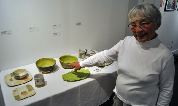 Poter Inge Anhorn proudly points to her green bowls at the are among the many lovely works by members of the Revelstoke Protters' Guild show, The Guild Sets The Table. David F. Rooney photo