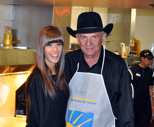 Local builder and businessman Peter Bernacki poses with Kendra Blakely after he dons his apron for a stint behind the counter. David F. Rooney photo