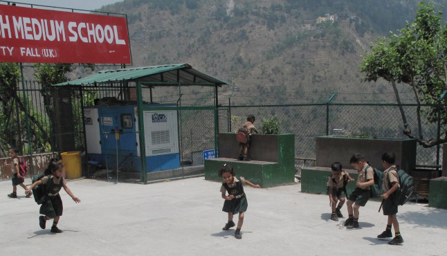 The children play soccer in the school courtyard, using an empty water bottle as a ball. Laura Stovel photo
