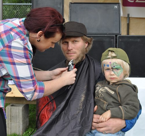 Michelle was a full-service stylist. Here, the Salon Safari stylist, trims back Stefan's beard as he holds his three year old son, Mattis. David F. Rooney photo