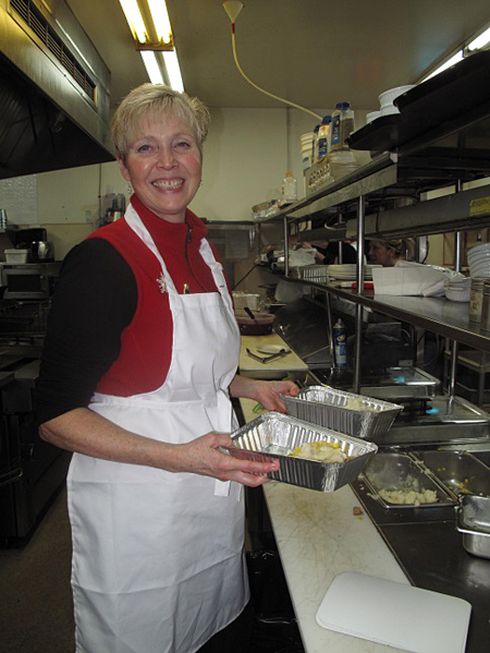 Lynne Welock works in the kitchen preparing take-away food — one of the options provided to diners. Laura Stovel photo