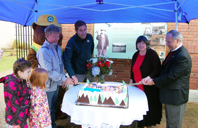 Fred Olsson, new Park Superintendent Nicholas Irving, Museum Curator Cathy English and Mayor David Raven pose for the ritual cake-cutting photo as Fred's granddaughters Tori and Miya Voykin look on. David F. Rooney photo