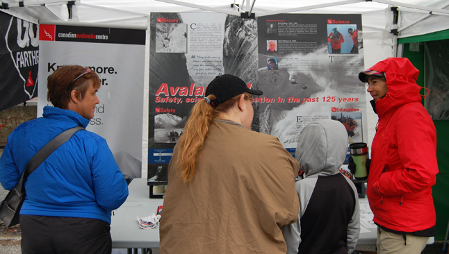 Nancy Geismar (right) describes the Canadian Avalanche Centre's work to curious visitors at the centennial celebration.  David F. Rooney photo