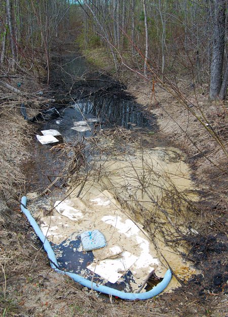 This is what 300-to-400 litres of used industrial oil and restaurant cooking oil looks like when some creep dumps it in a ditch rather than disposing of it properly. This toxic goo was intentionally dumped in a ditch along Begbie Road at the intersection with Nixon Road near the Wright Machine Shop on Thursday night and was discovered by a local resident on Friday morning. What you are looking at are oil-absorbent pads and a pale-blue oil-contantment boom. This ugly stuff did not leak from somewhere, nor was it spilled. It is easy to determine it was intentionally dumped because there are no signs of it up-ditch towards Highway 23S. And there is a lesser amount of it in the ditch across the road. David F. Rooney photo