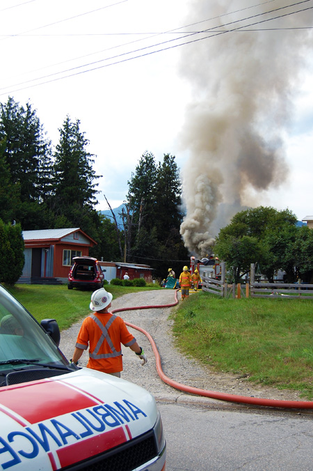 Hose adjusted, the BC Hydro worker gazes up at the billowing smoke. David F. Rooney photo