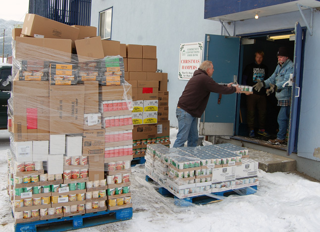 Volunteers Ben Blair, Mark Tottenham and Larry Olsson unload boxes of food from the pallets delivered to the Food Bank on Tuesday morning, December 2, by Cooper's Foods. The generosity of companies and individuals ensure the ongoing success of the Food Bank and, at this time of year, the Christmas Hamper Depot.  David F. Rooney photo