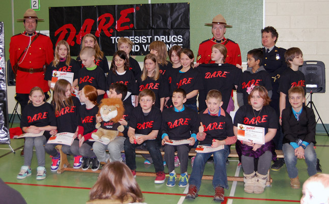 Const. Seanan Sharpe and Cpl. Eric Page pose with these young graduates of the DARE program at Columbia Park Elementarey School during a ceremony early Monday evening, February 23. The kids received  certificates and cool DARE T-shirts. David F. Rooney photo