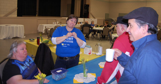 Wendy Larson and Cheryl Fry chat with Ron Holoday and Paul Suraci (right) at the entrance to the Canadian Cancer Society's Daffodil Tea, which was held at the Community Centre on Saturday, March 28. The tea was intended to honour the men and women who care for cancer victims as well as cancer survivors. David F. Rooney photo 