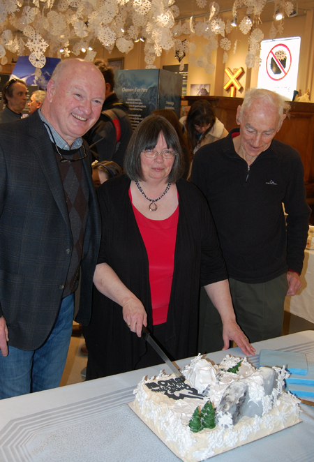 Assisted by Mayor Mark McKee (left) and retired avalanche researcher Peter Schaerer, Museum Curator Cathy English prepares to cut the gorgeous cake created especially for this event by the Modern Bakery. David F. Rooney photo