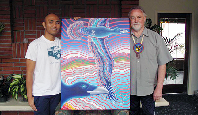 Activists and artists Karie Garnier (right) and Mat Falcon Padua (left) display one of Garnier’s colourful paintings that he is using to raise awareness of the plight of the people of Fuga Island in the Philippines. Laura Stovel photo