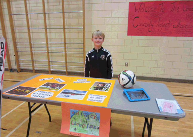 Reed Kelly taught us about Lionel Messi (a famous soccer player) and Ted Ligety (a famous downhill skier) at the Curiosity Project display. “Did you know Lionel Messi has 417 goals total?” he asked. Todd Hicks photo. Caption by Amelie Delesalle